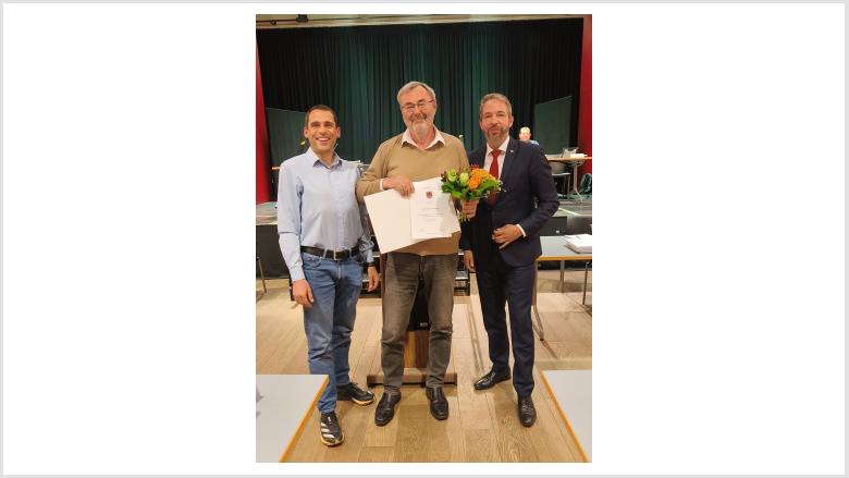 Detlef Levenhagen erhält eine Urkunde und einen Blumenstrauß vom Bürgervorsteher und vom Bürgermeister